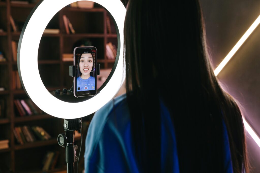 Girl filming on phone with a ring light.